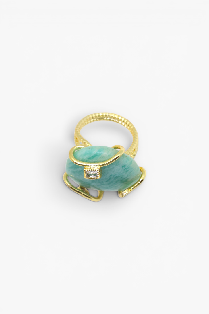 Gold ring with a green stone on a white background