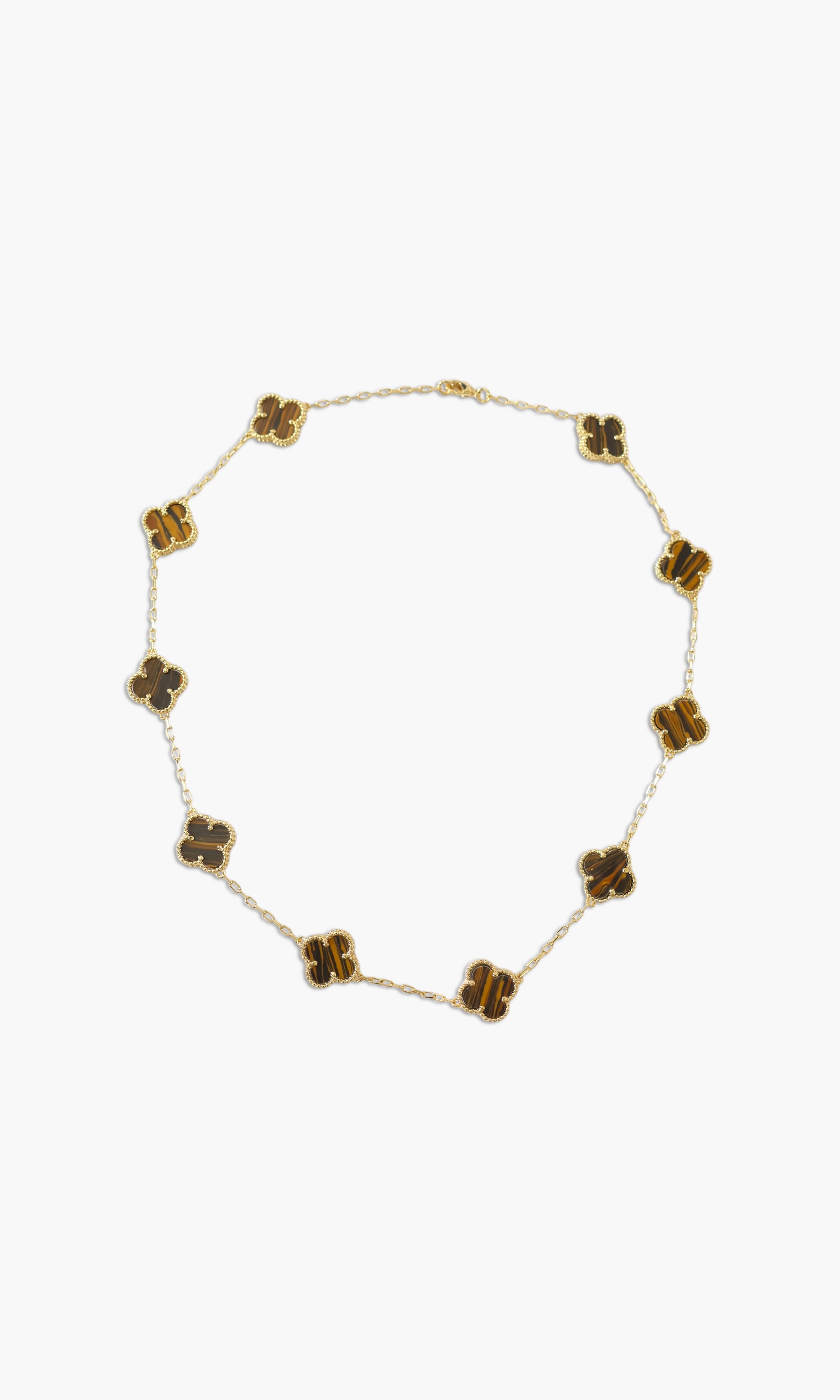 A person wearing multiple necklaces with amethyst stones and gold accents. The necklaces are part of a stack, and the person is holding some of the necklaces, showcasing the jewelry.