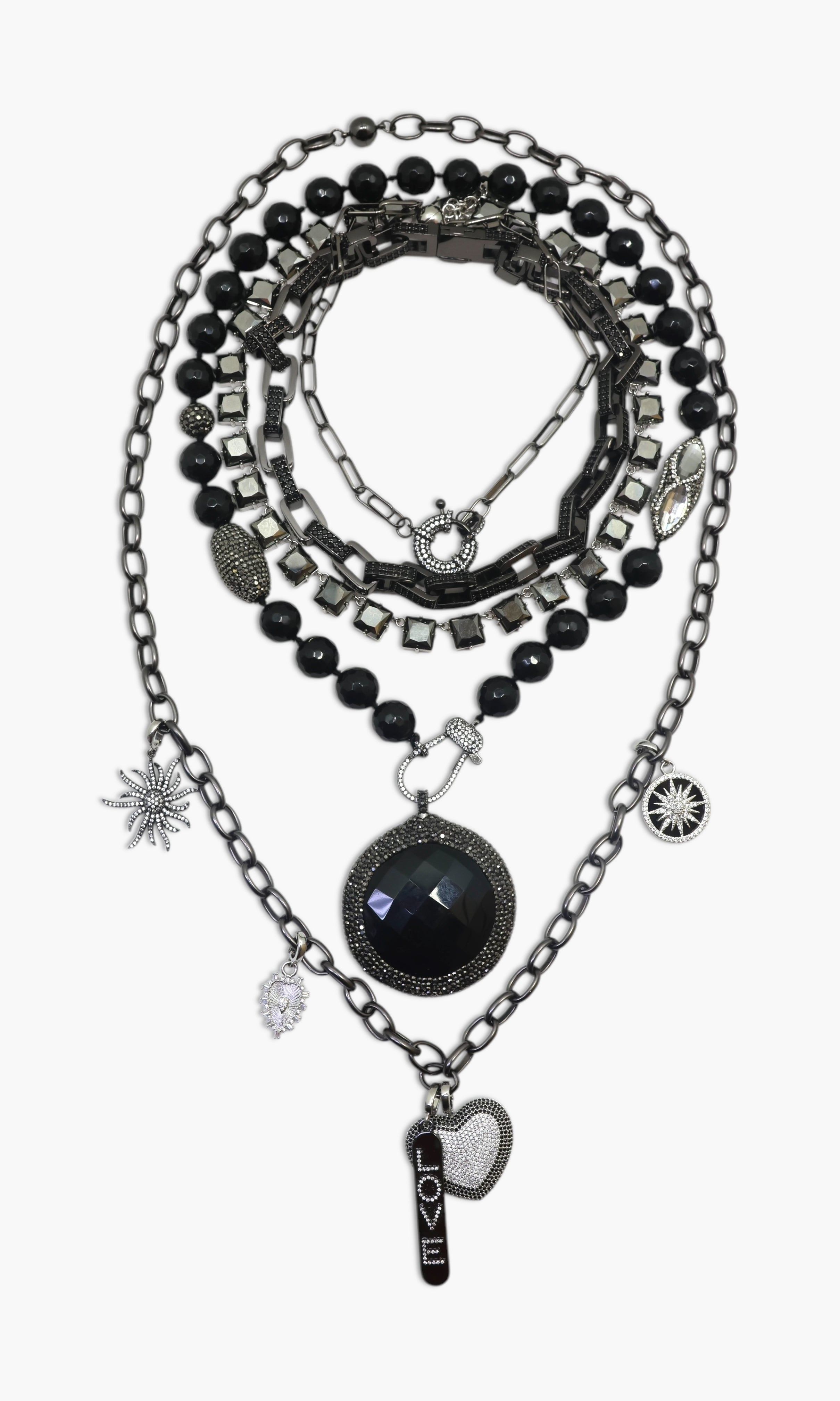 A person wearing multiple necklaces with onyx and gun metal colors.