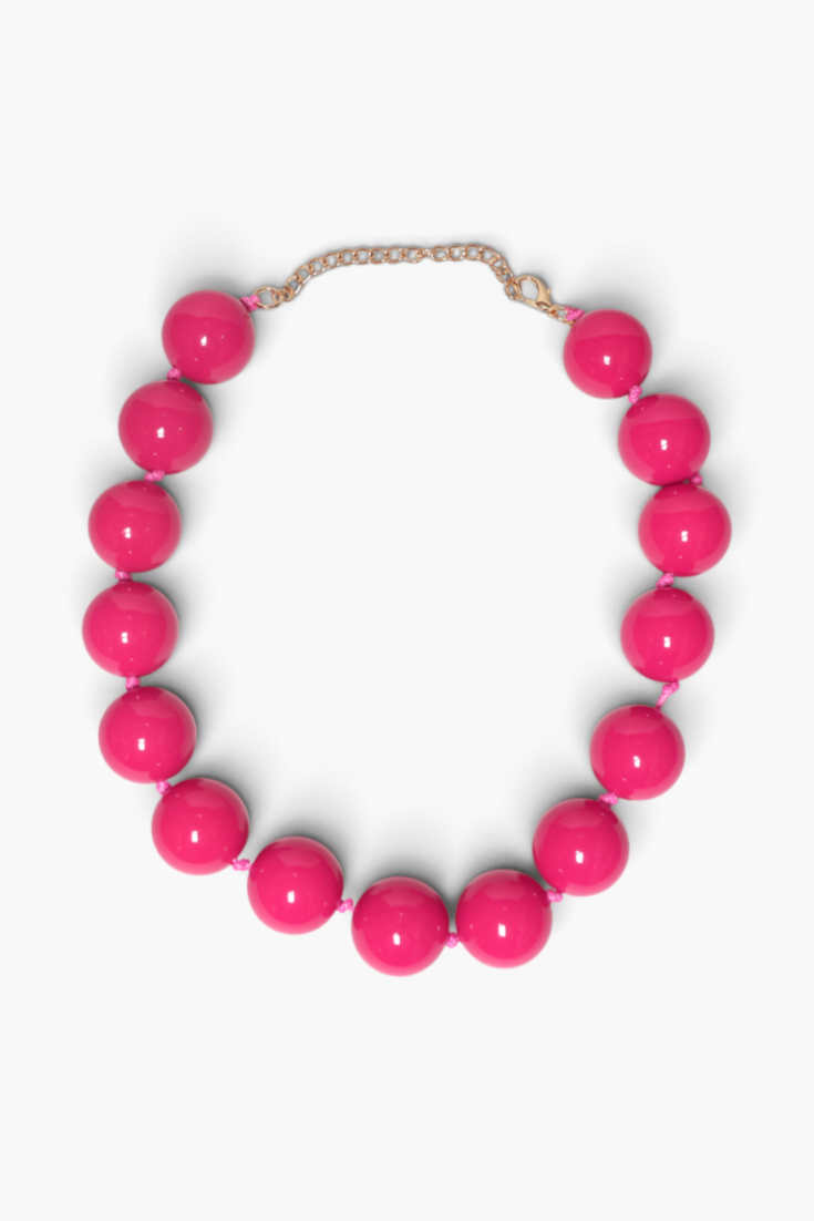 A chunky beaded necklace with glossy hot pink spherical beads and a gold-tone chain clasp, displayed on a clean white background.