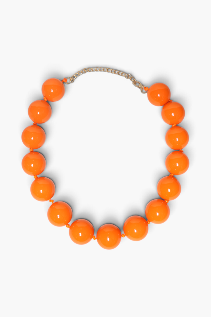 A chunky beaded necklace made of glossy, bright orange spherical beads, connected by a thin silver-toned chain extender, shown on a clean white background.