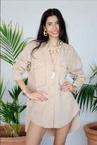 Woman wearing a beige shirt with plants in the background