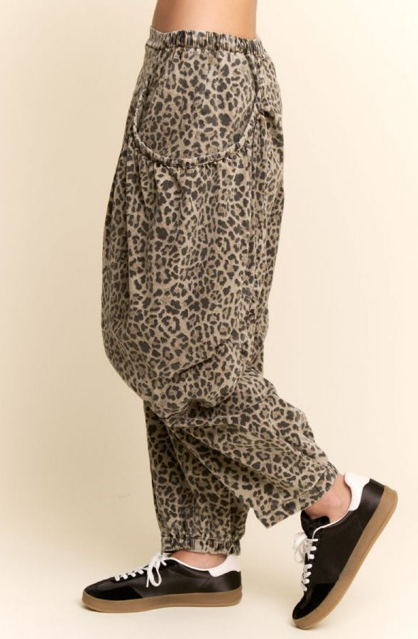 Leopard print pants worn by a person on a beige background