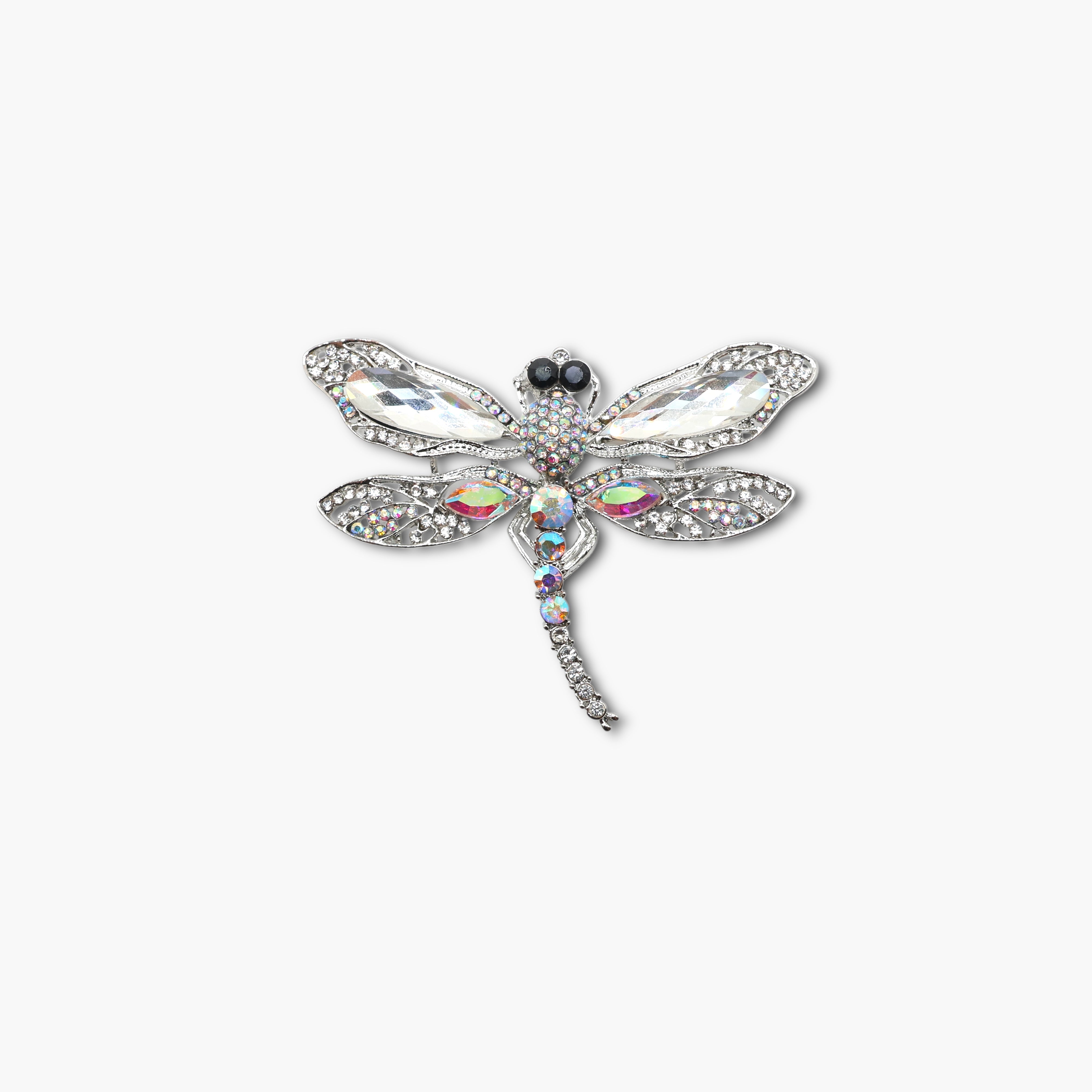 Decorative dragonfly brooch with gemstones on a white background