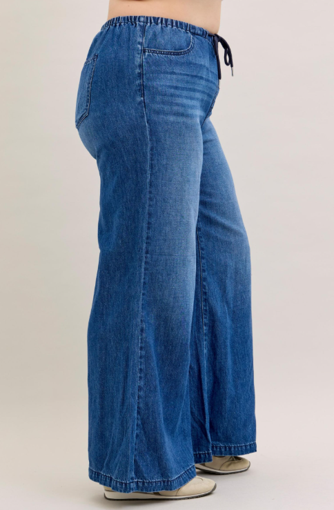 Blue jeans worn by a person on a plain background