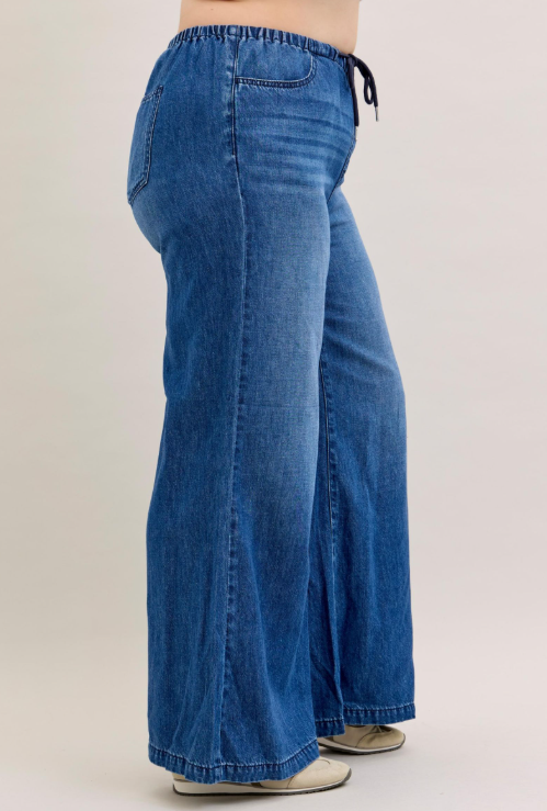 Blue jeans worn by a person on a plain background