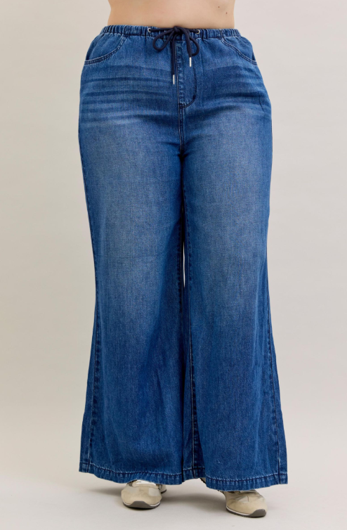 Wide-leg blue jeans on a plain background
