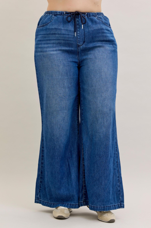 Wide-leg blue jeans on a plain background