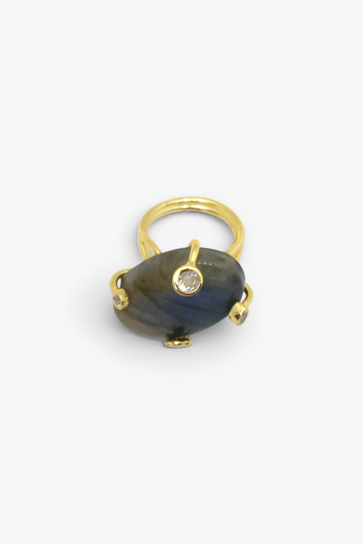 Gold ring with a large blue stone on a white background