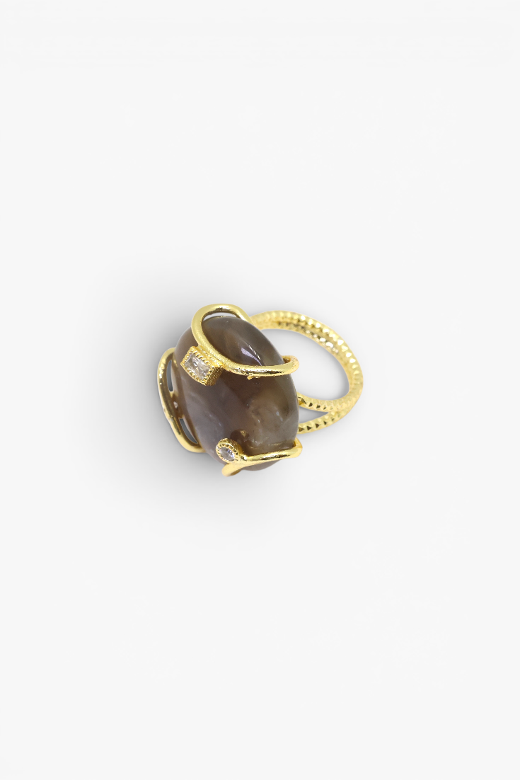 Polished natural stone statement ring with crystal accents in a textured gold-tone setting.