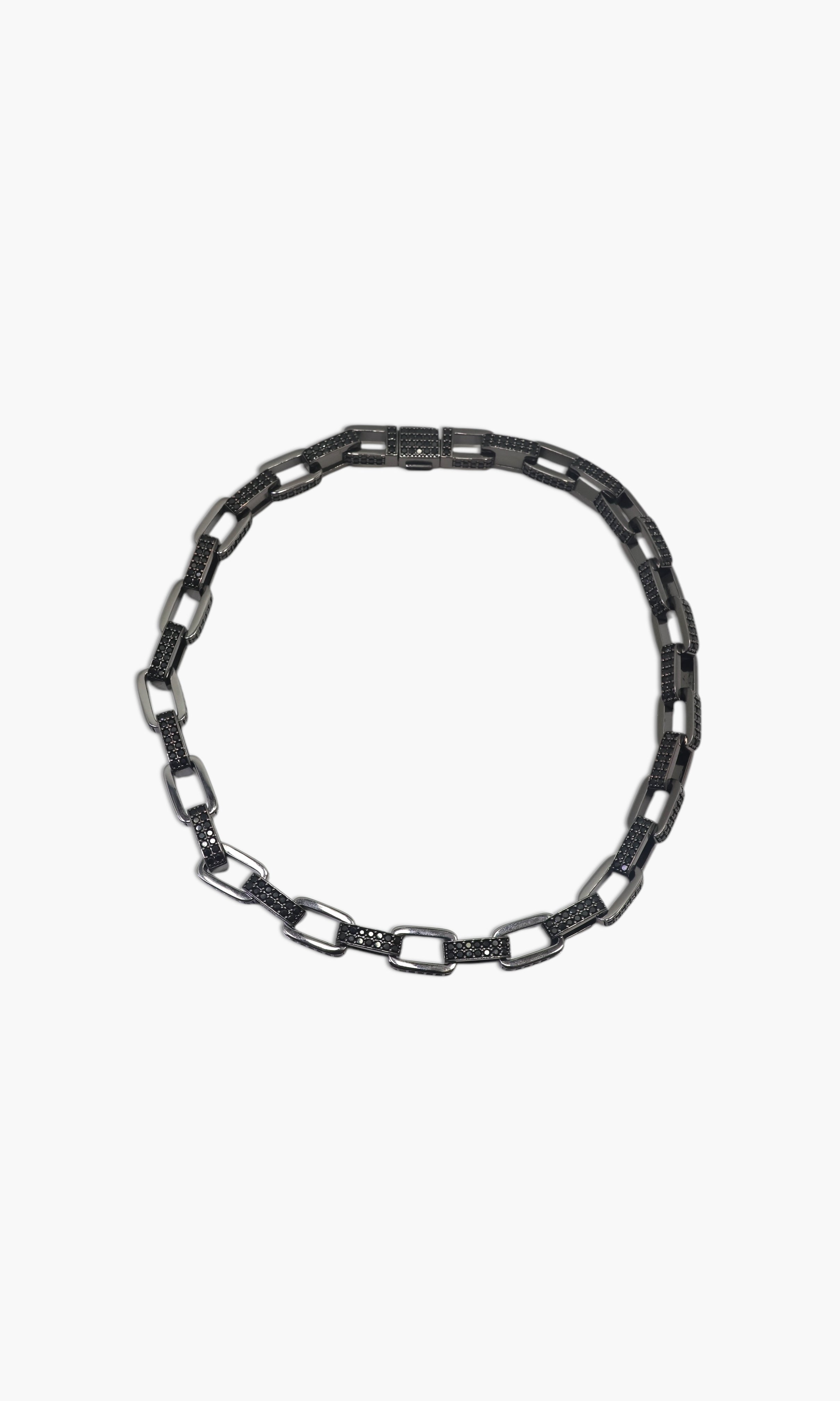 A person wearing multiple necklaces with onyx and gun metal colors.