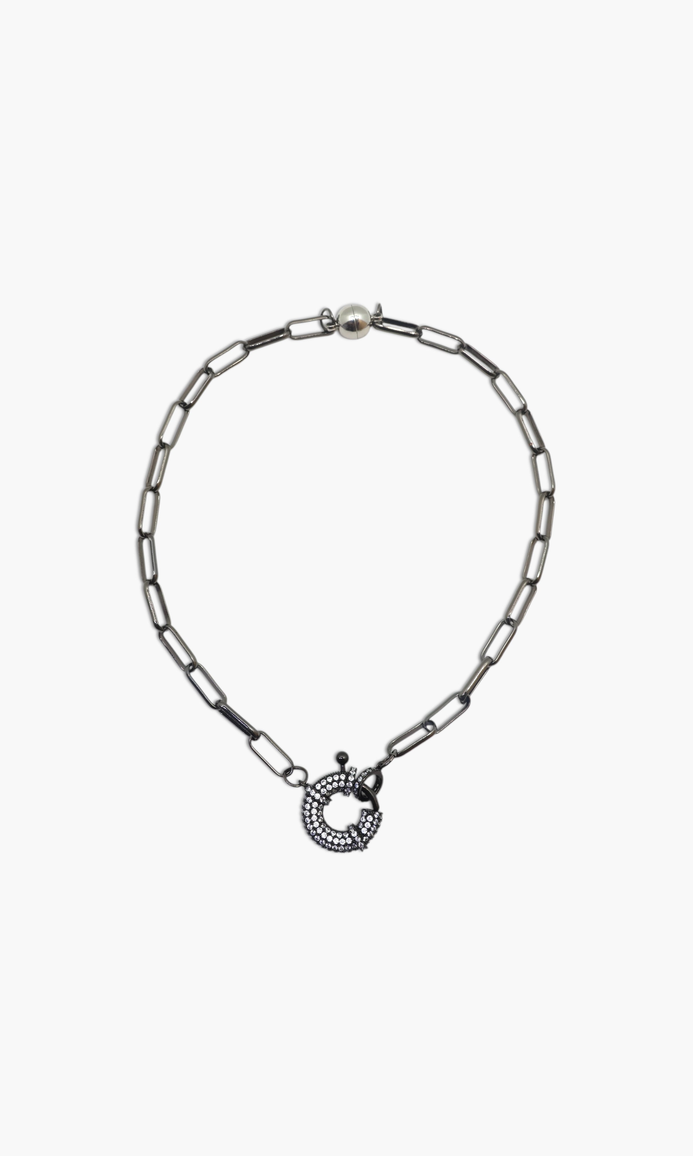 A person wearing multiple necklaces with onyx and gun metal colors.