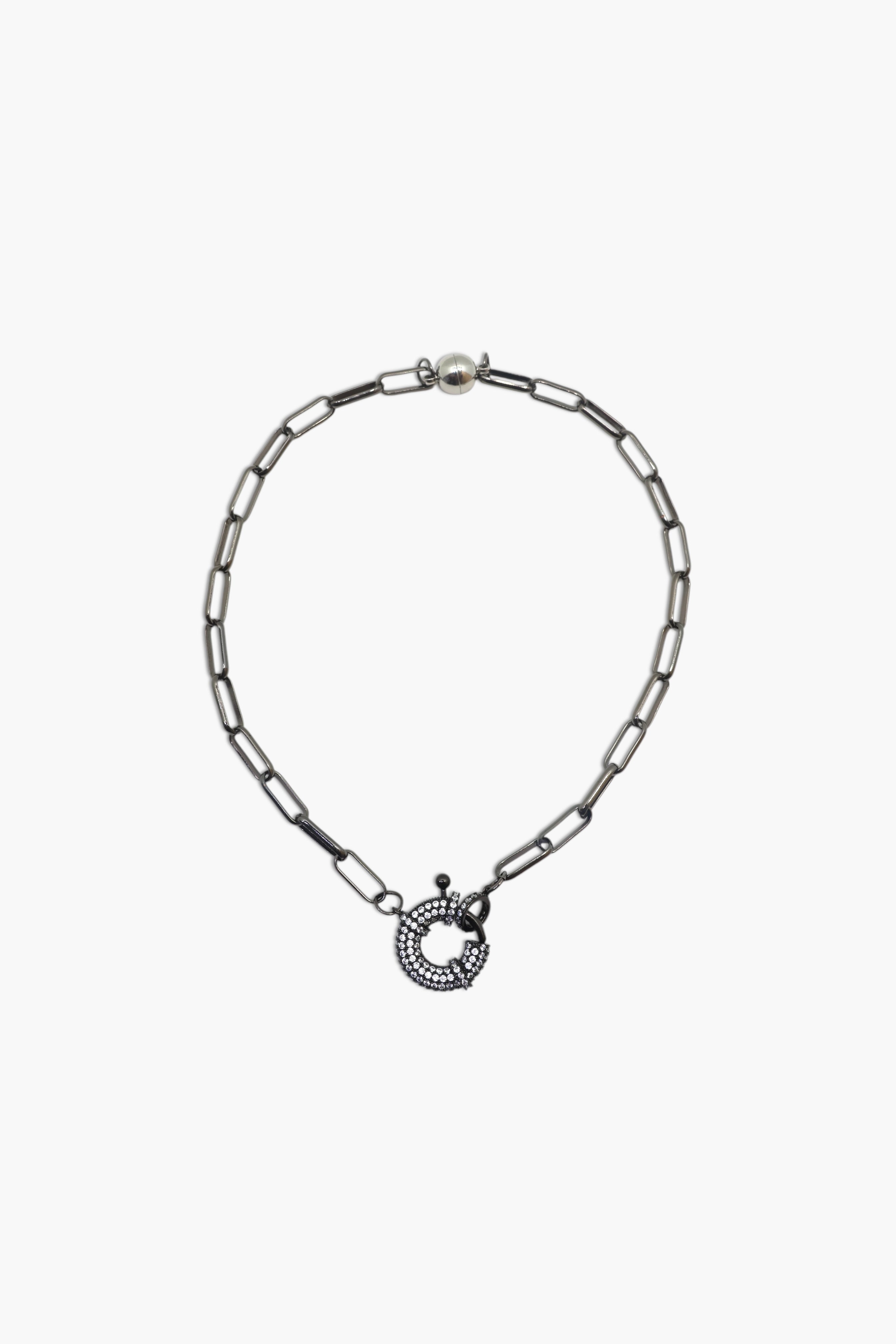 A person wearing multiple necklaces with onyx and gun metal colors.