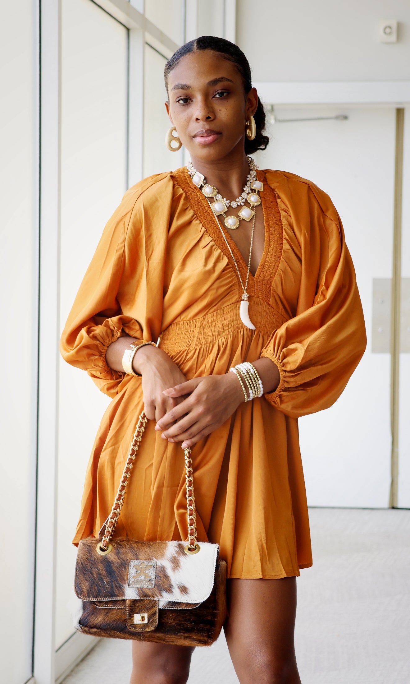 Woman wearing a orange silk dress with a white background
