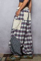 Person wearing a plaid skirt with a textured pattern and a pocket on a gray background