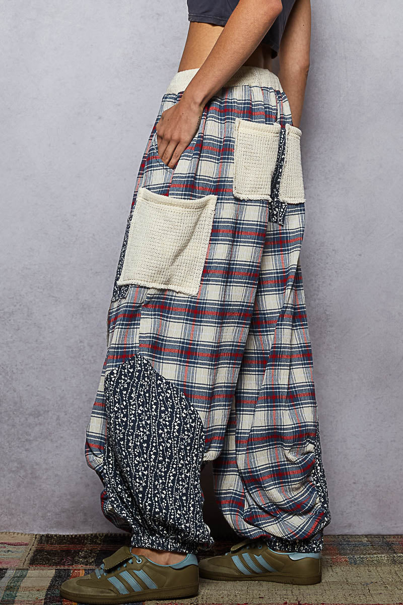 Person wearing a plaid skirt with a textured pattern and a pocket on a gray background