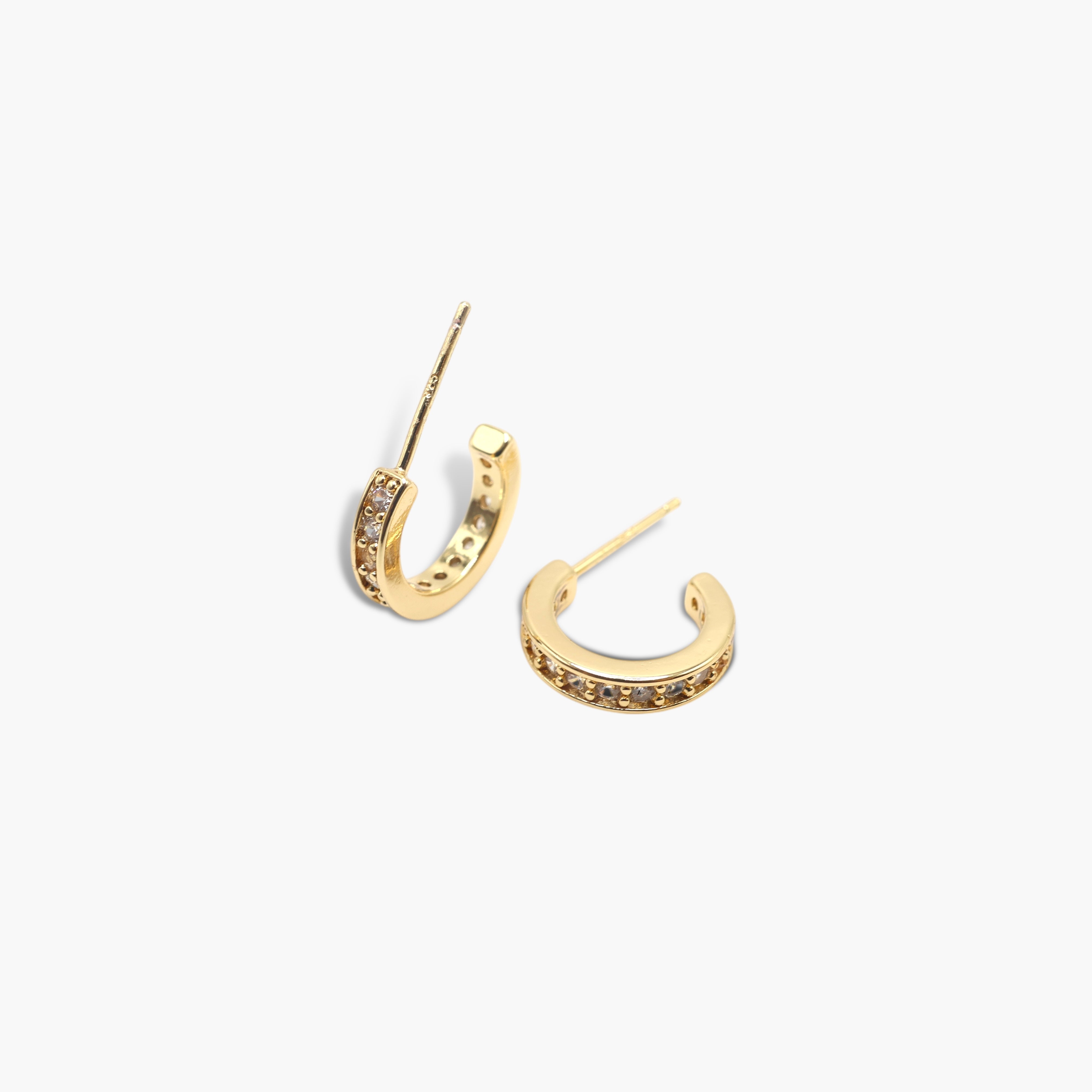 A pair of gold-colored hoop earrings with a pave of small, possibly clear or colored stones around the hoop.