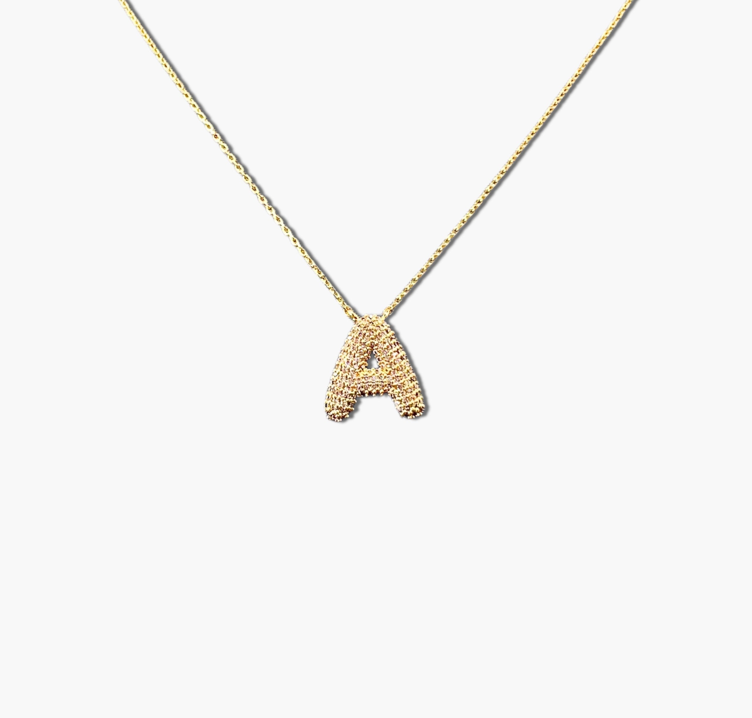 A gold-plated letter necklace with a pleated design on the pendant.