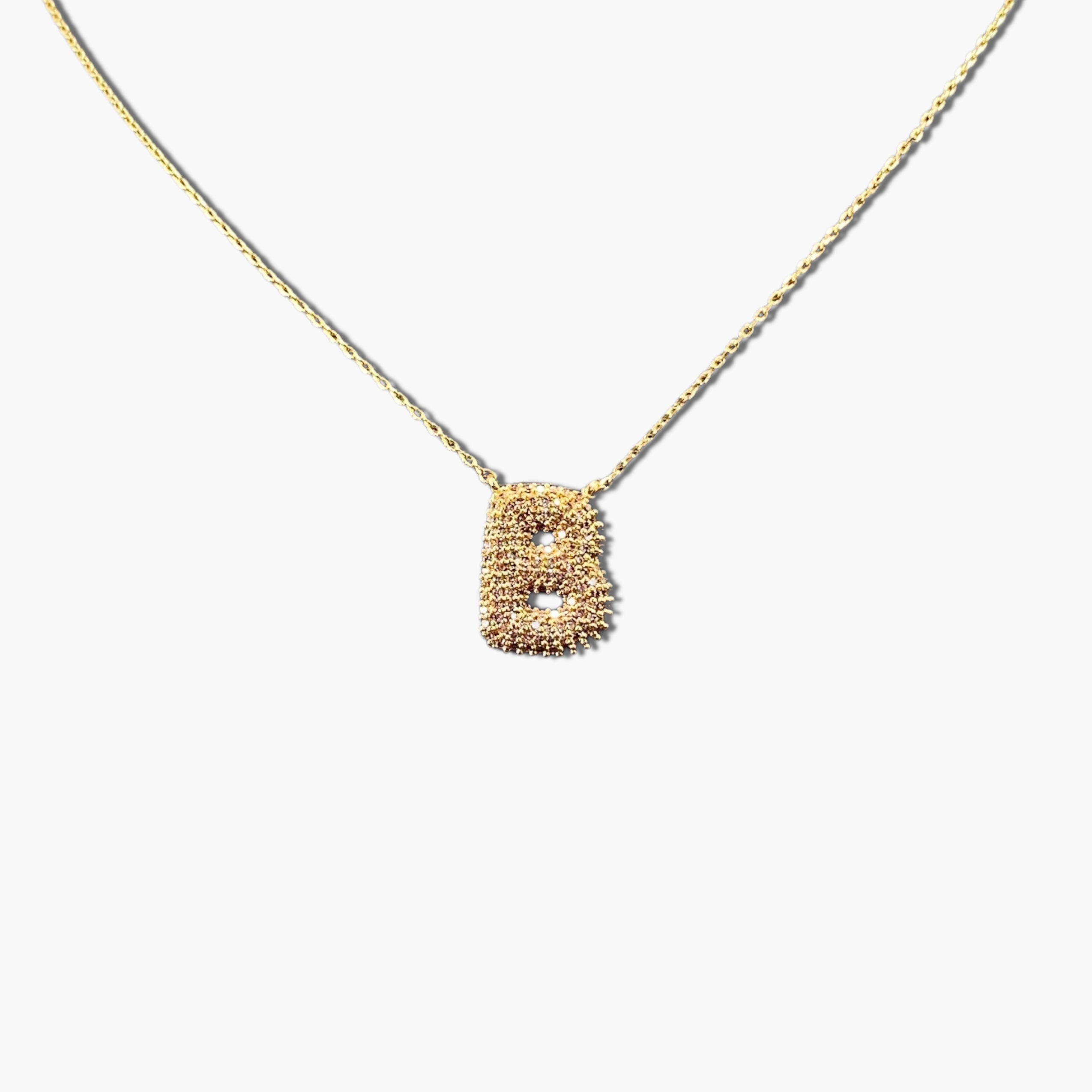 A gold-plated letter necklace with a pleated design on the pendant.