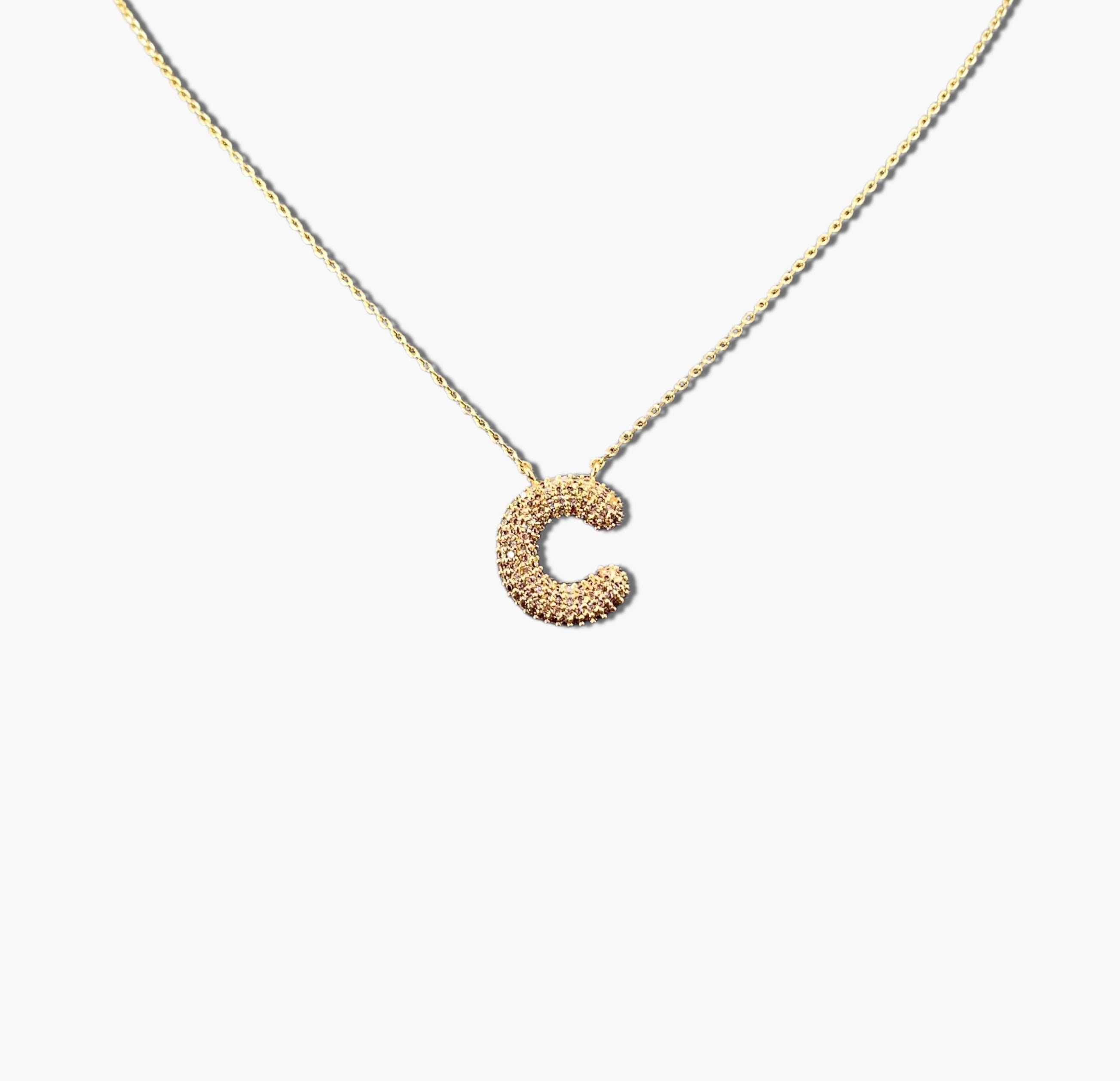 A gold-plated letter necklace with a pleated design on the pendant.