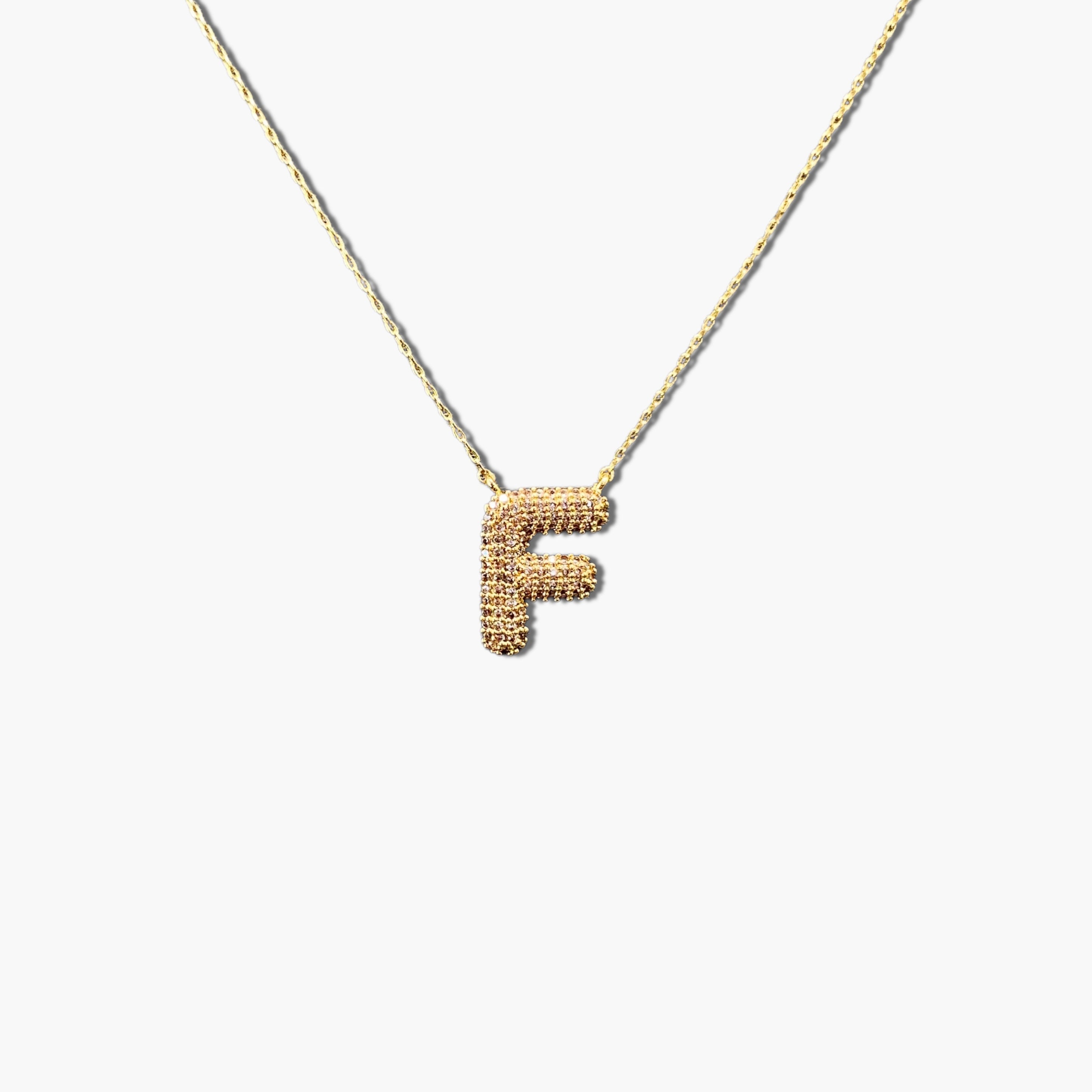 A gold-plated letter necklace with a pleated design on the pendant.