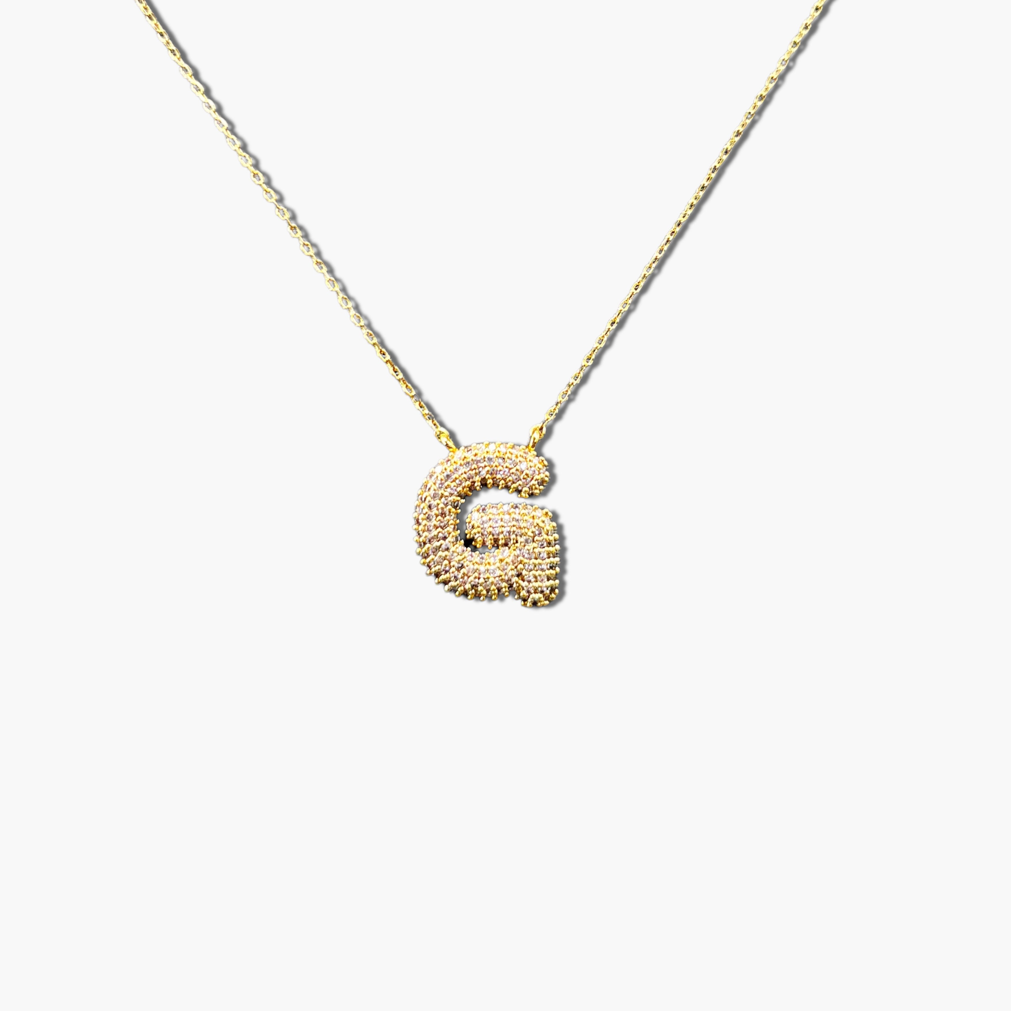 A gold-plated letter necklace with a pleated design on the pendant.