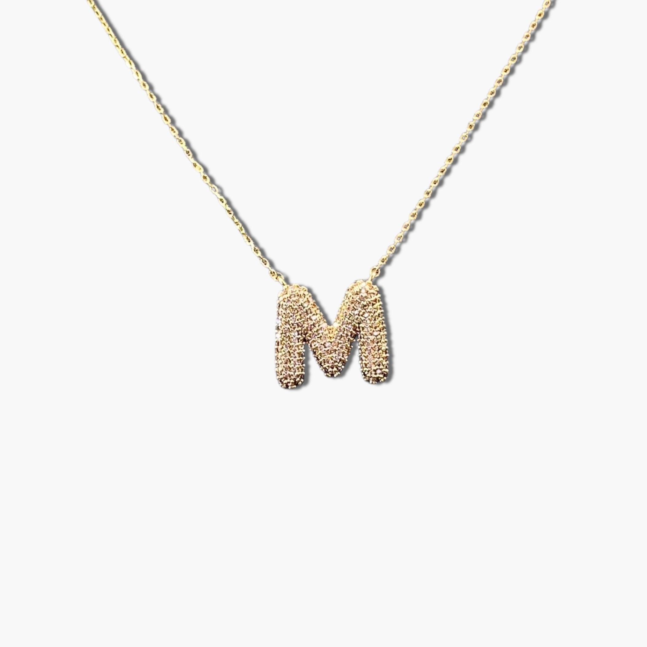 A gold-plated letter necklace with a pleated design on the pendant.
