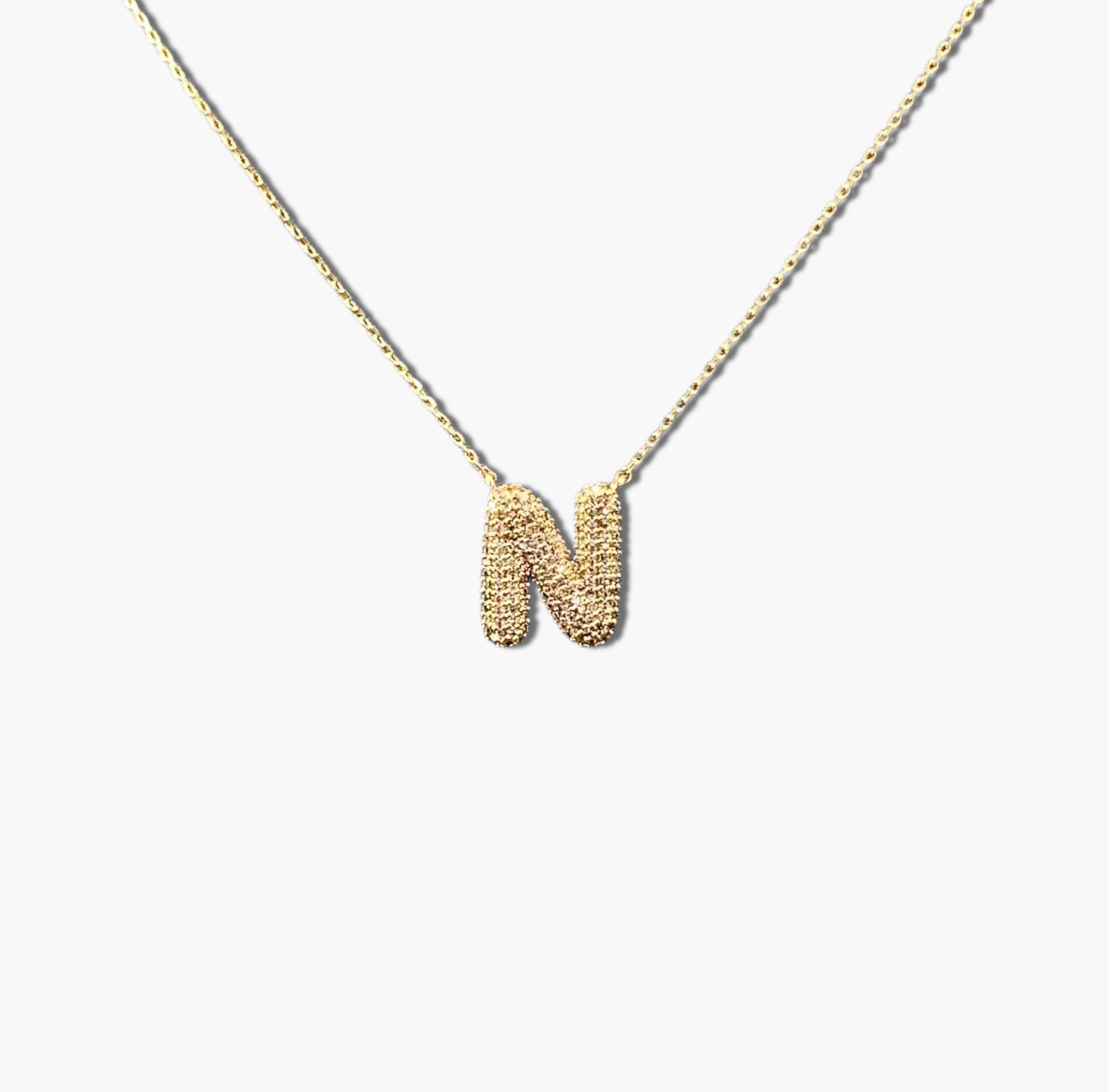 A gold-plated letter necklace with a pleated design on the pendant.