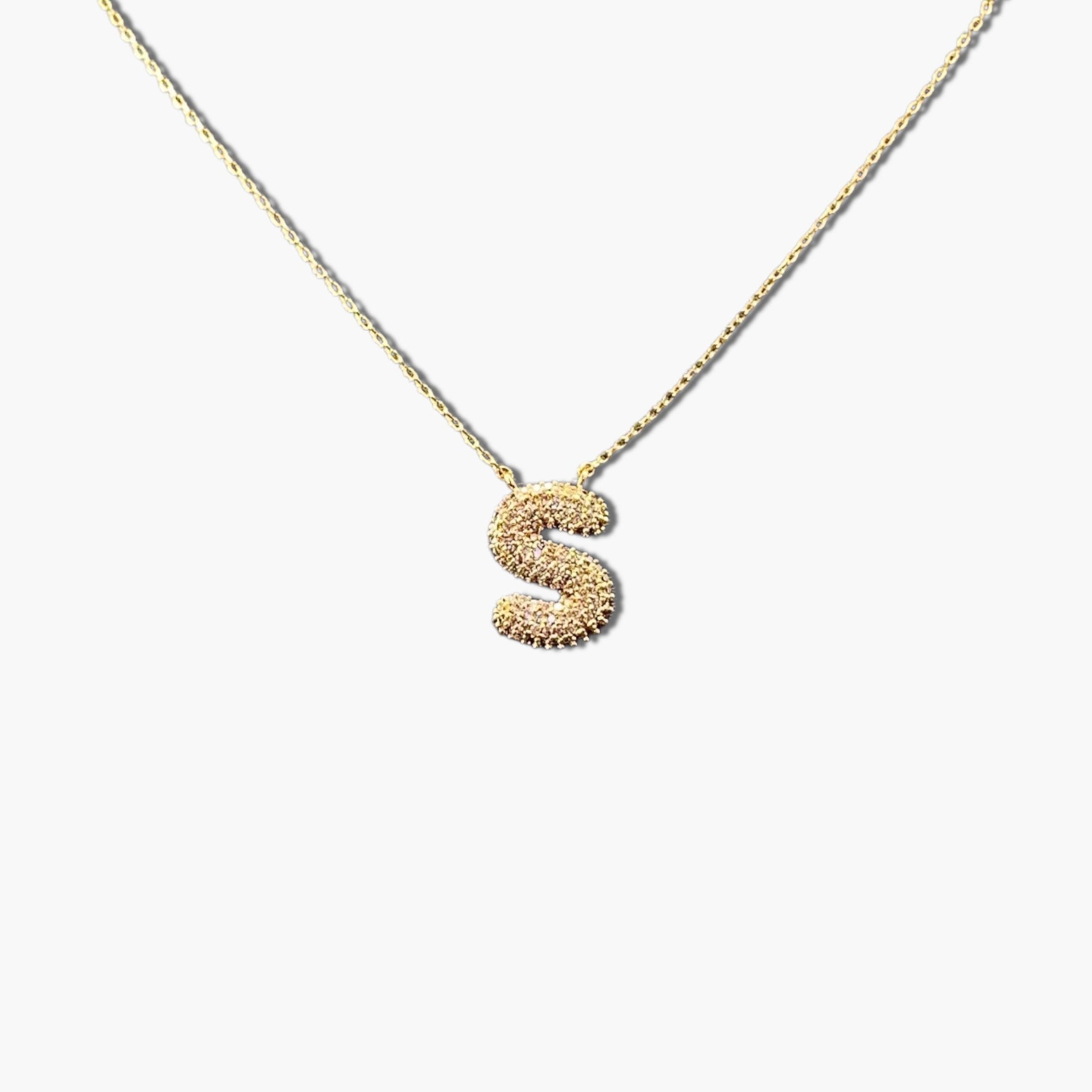 A gold-plated letter necklace with a pleated design on the pendant.