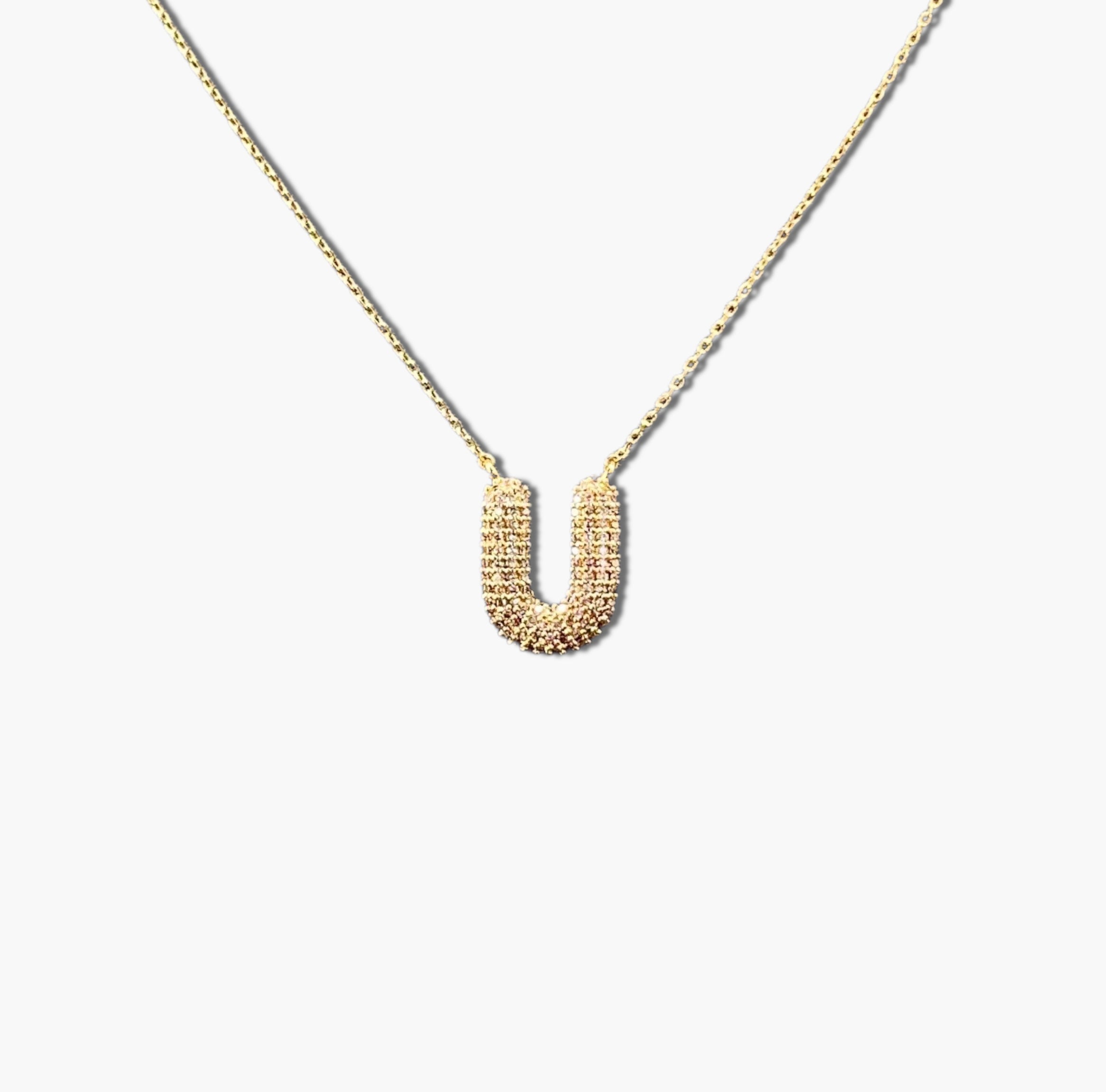 A gold-plated letter necklace with a pleated design on the pendant.