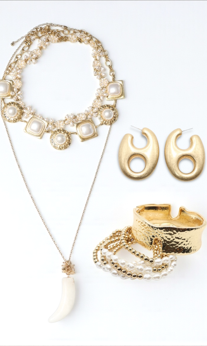 Gold necklace, earrings, and ring on a white background