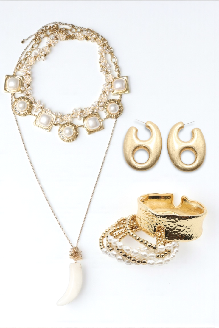 Gold necklace, earrings, and ring on a white background