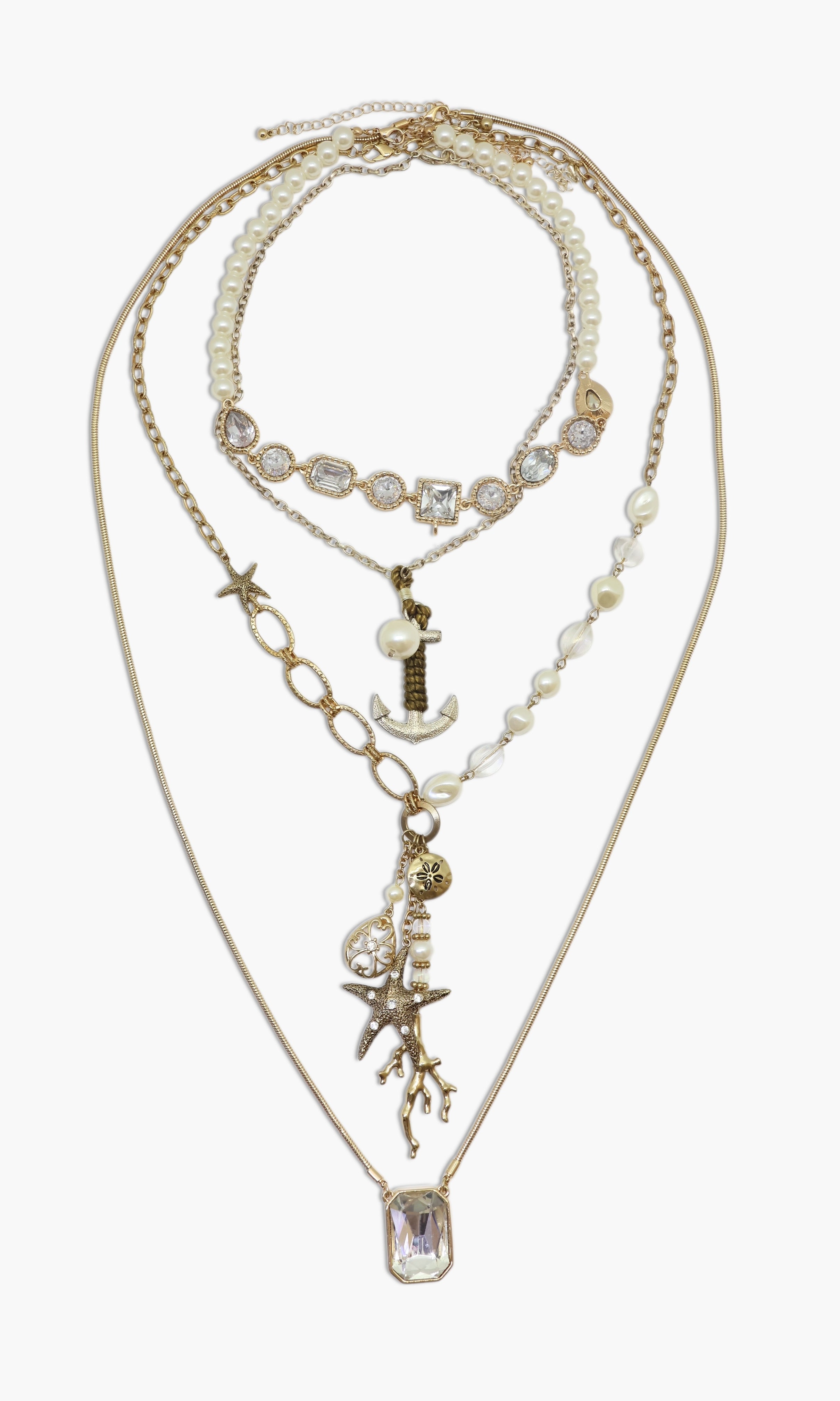A set of layered necklaces with pearl star fish and anchor charms on a gold-tone chain.