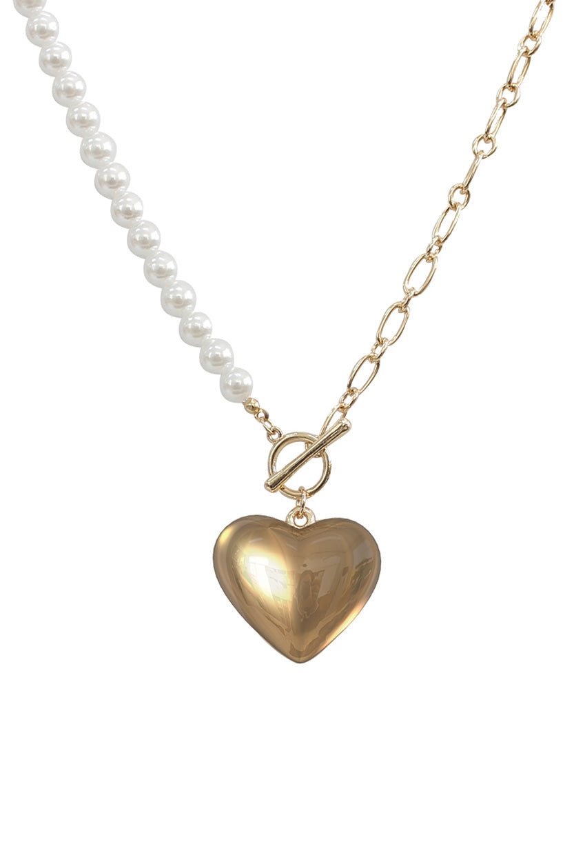 Necklace with heart-shaped gold pendant and pearl chain on a white background