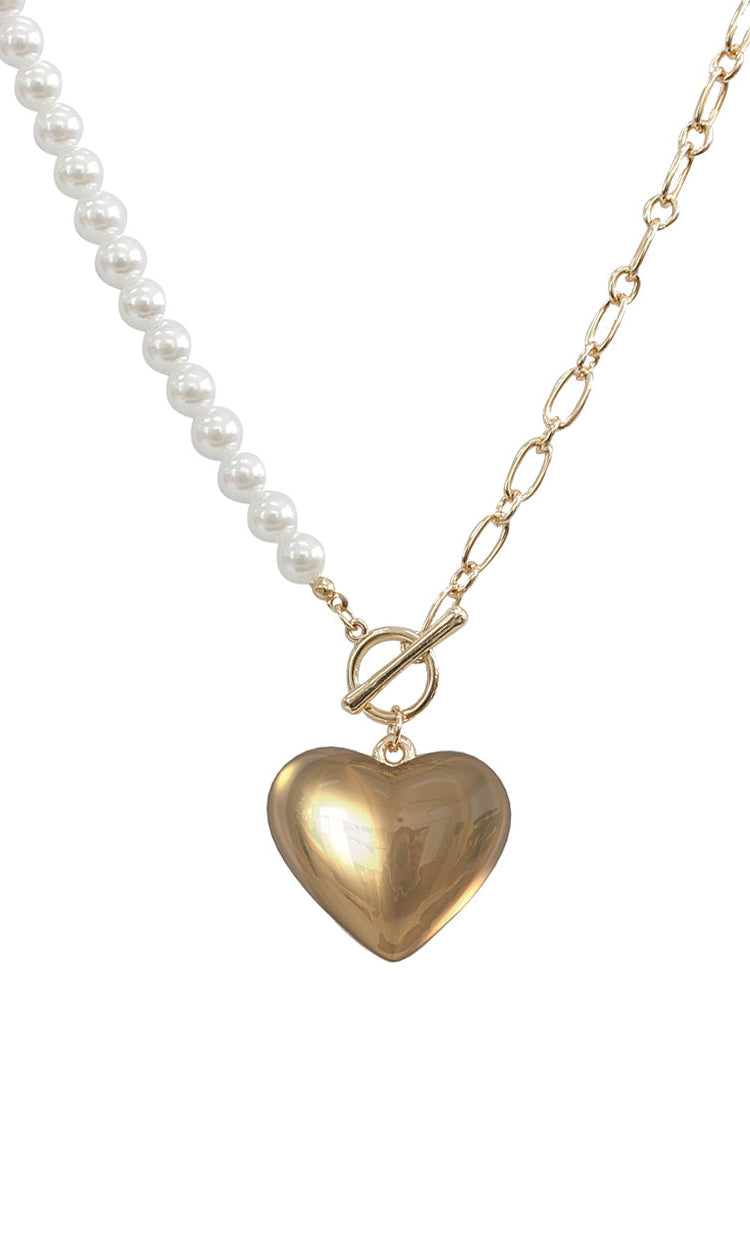 Necklace with heart-shaped gold pendant and pearl chain on a white background