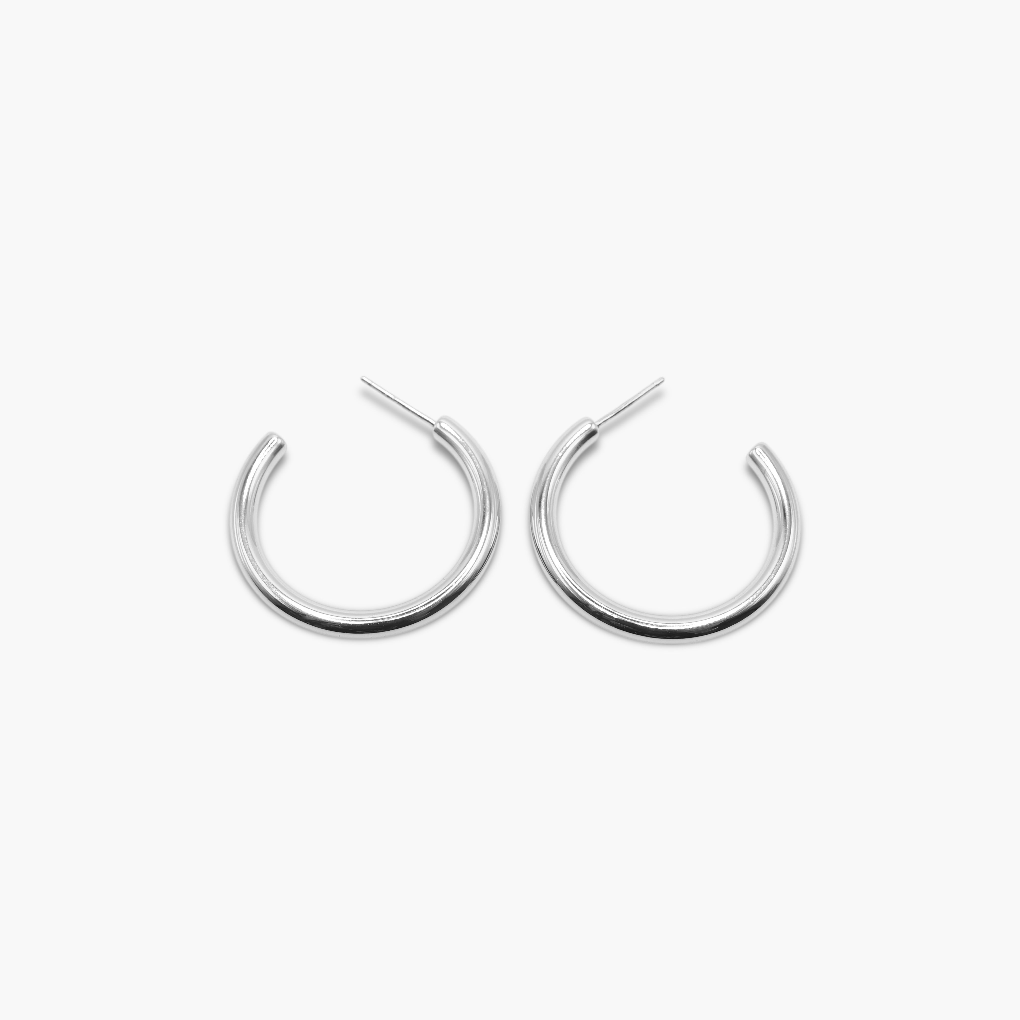 A pair of silver-colored hoop earrings with a textured surface on a white background.