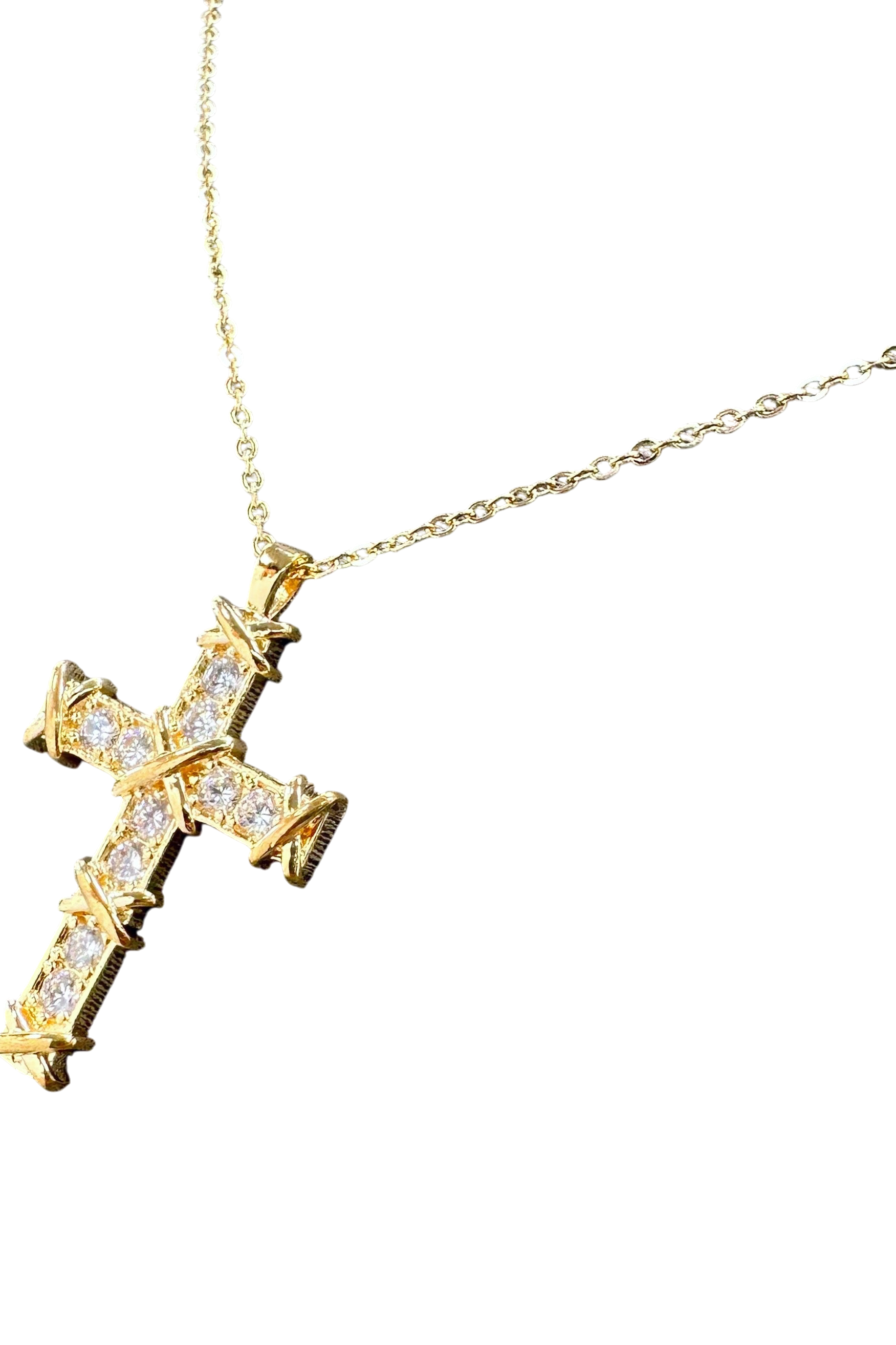Gold cross necklace with diamonds on a white background