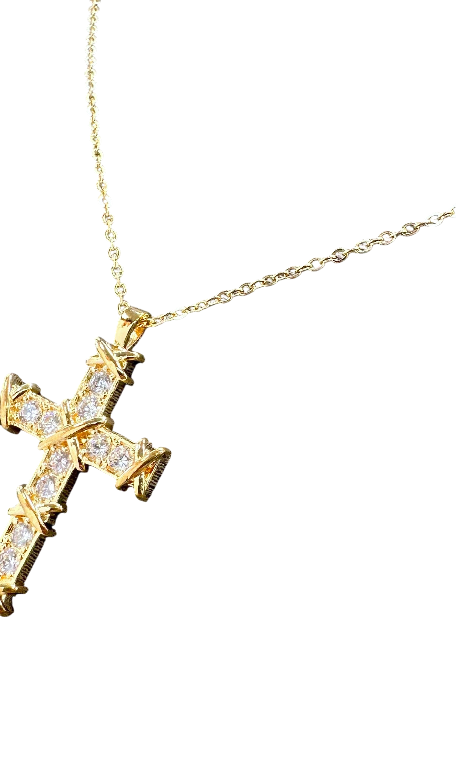 Gold cross necklace with diamonds on a white background