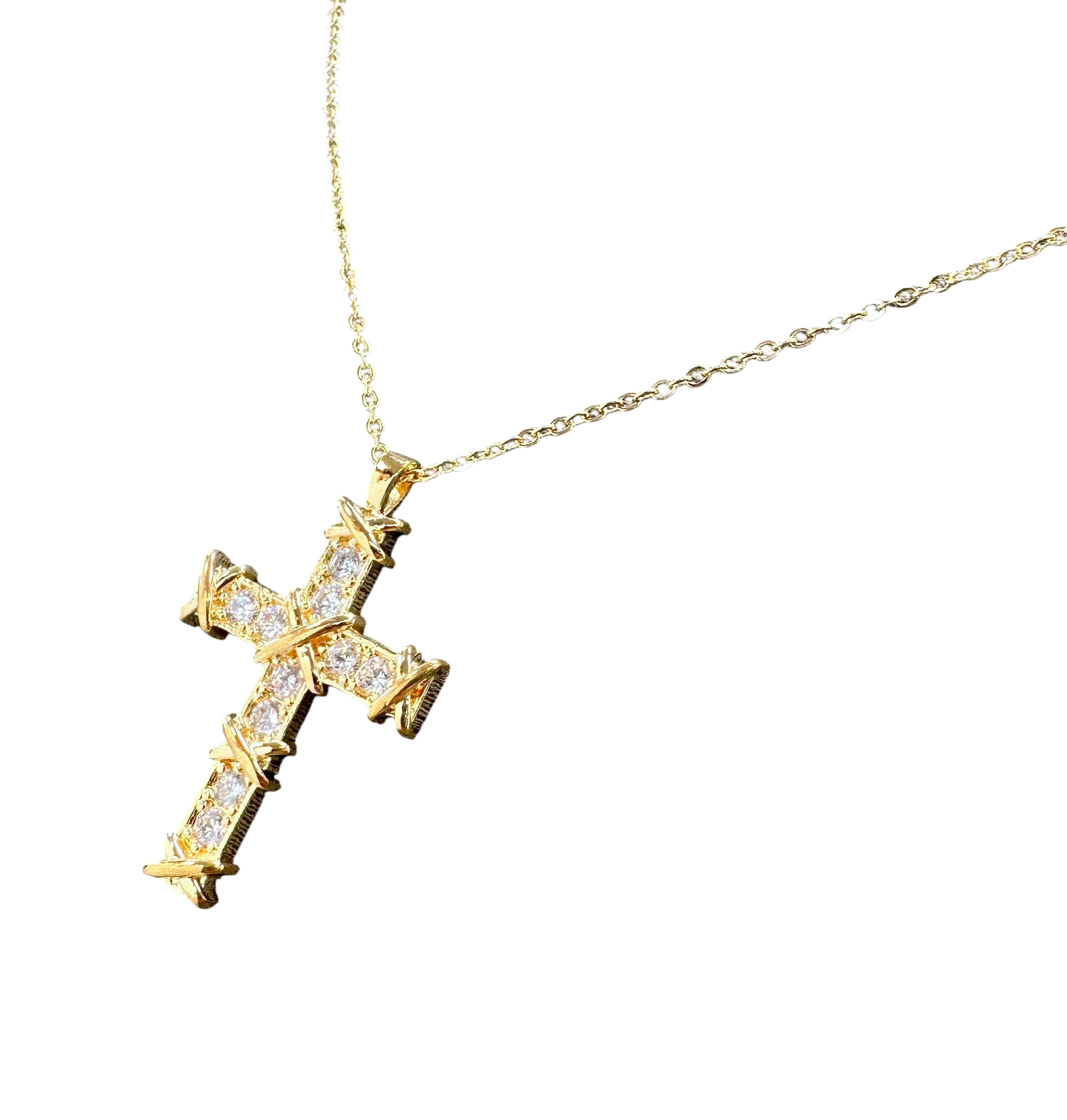 Gold cross necklace with diamonds on a white background