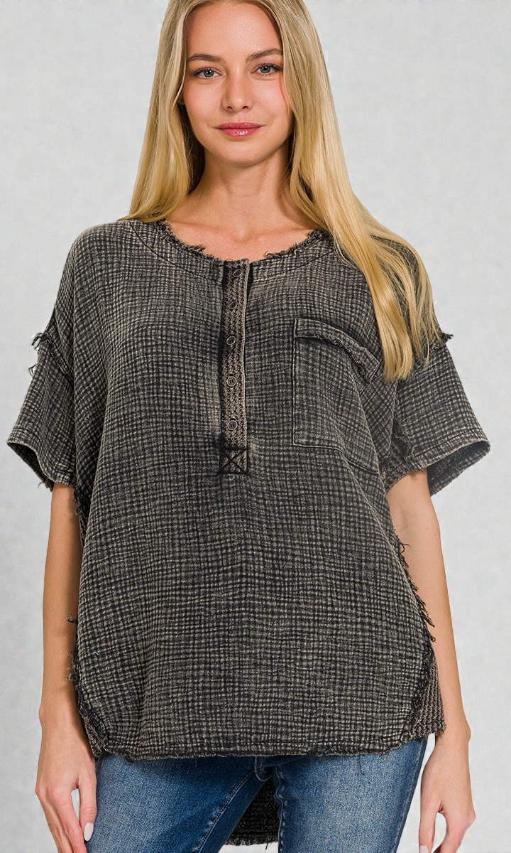 Woman wearing a gray checkered blouse with short sleeves on a gray background