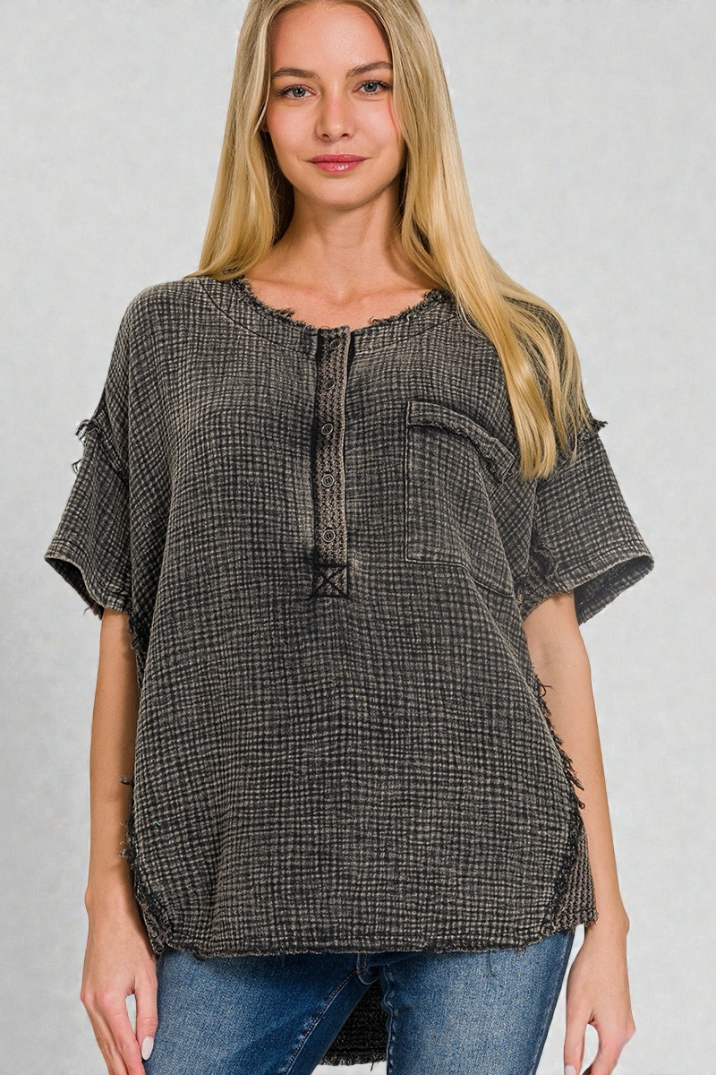 Woman wearing a gray checkered blouse with short sleeves on a gray background