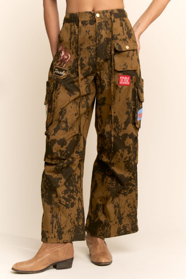 Camouflage cargo pants with patches on a beige background