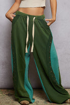 Green wide-leg pants with a textured pattern on a neutral background