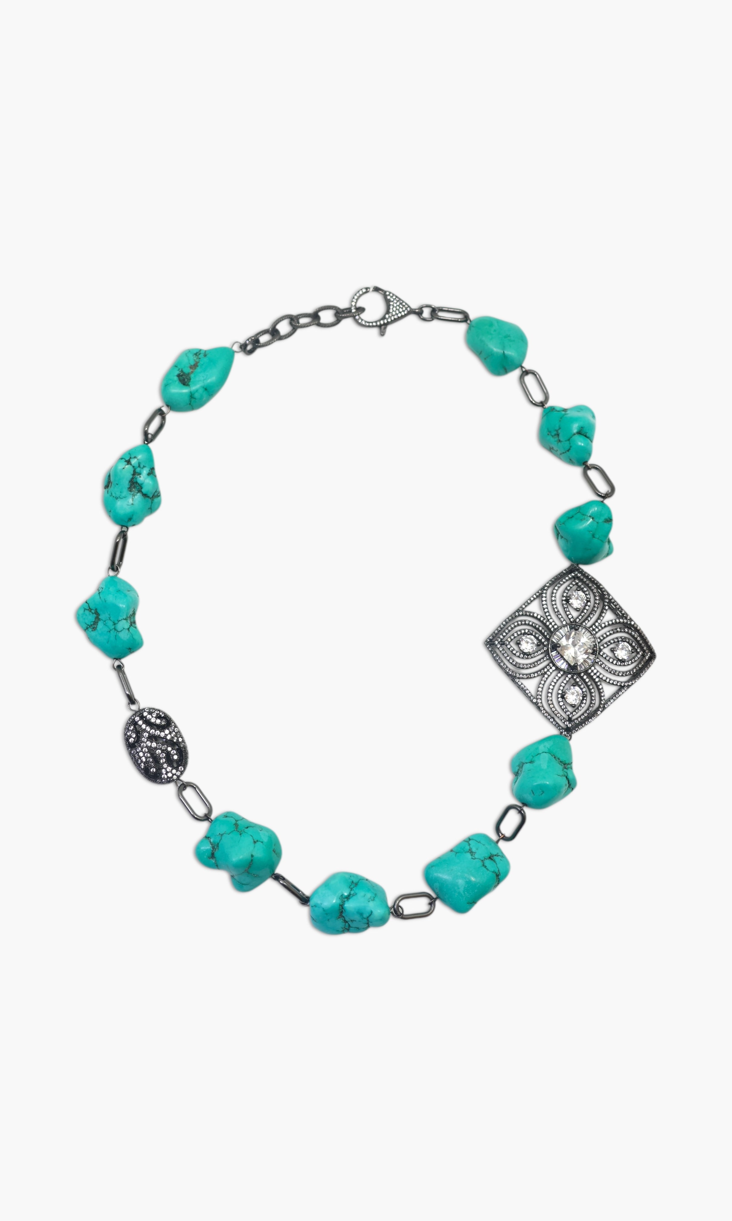 A woman wearing a turquoise and black stone necklace stack with matching earrings.