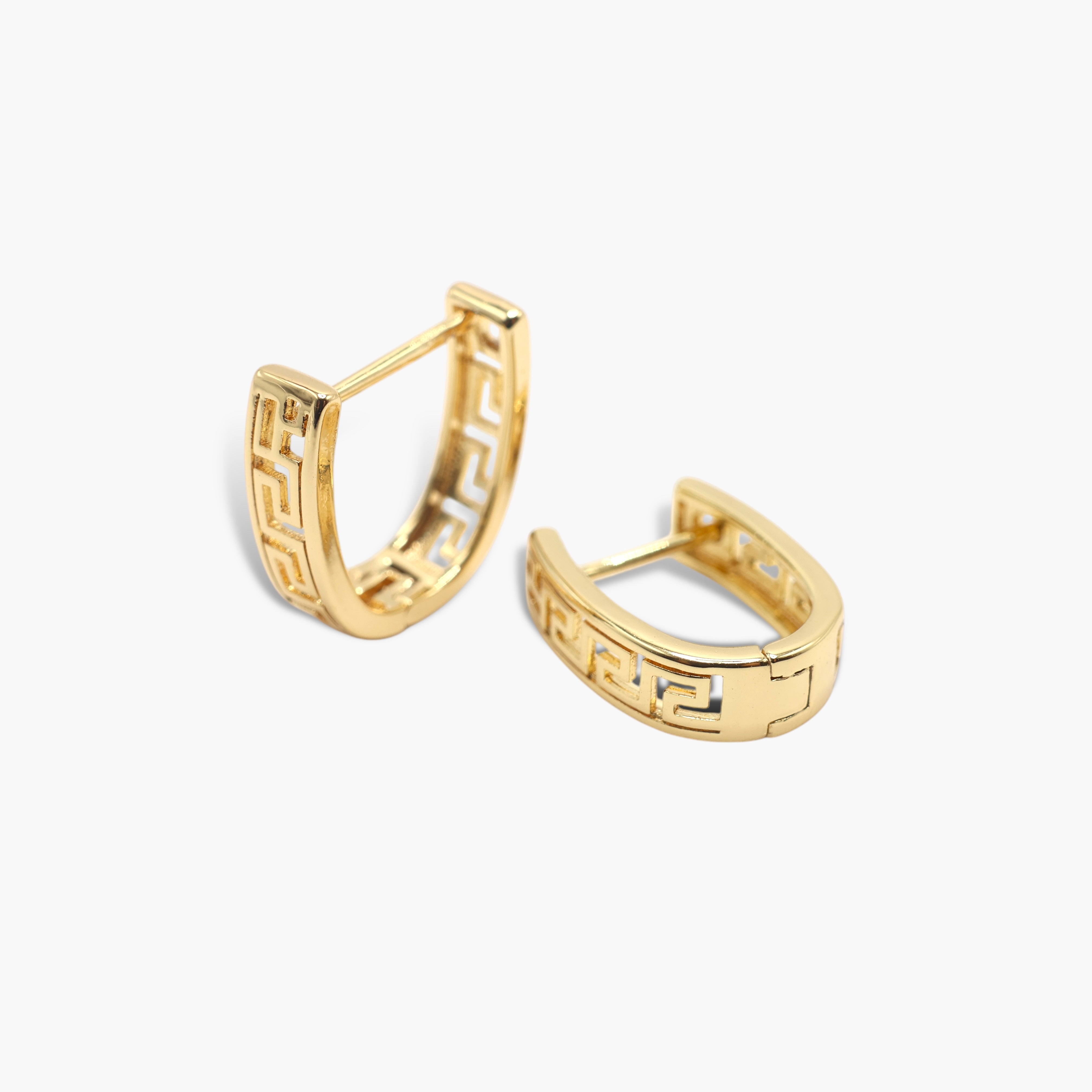 A pair of gold-colored hoop earrings with a geometric pattern on the U-shaped hoop.