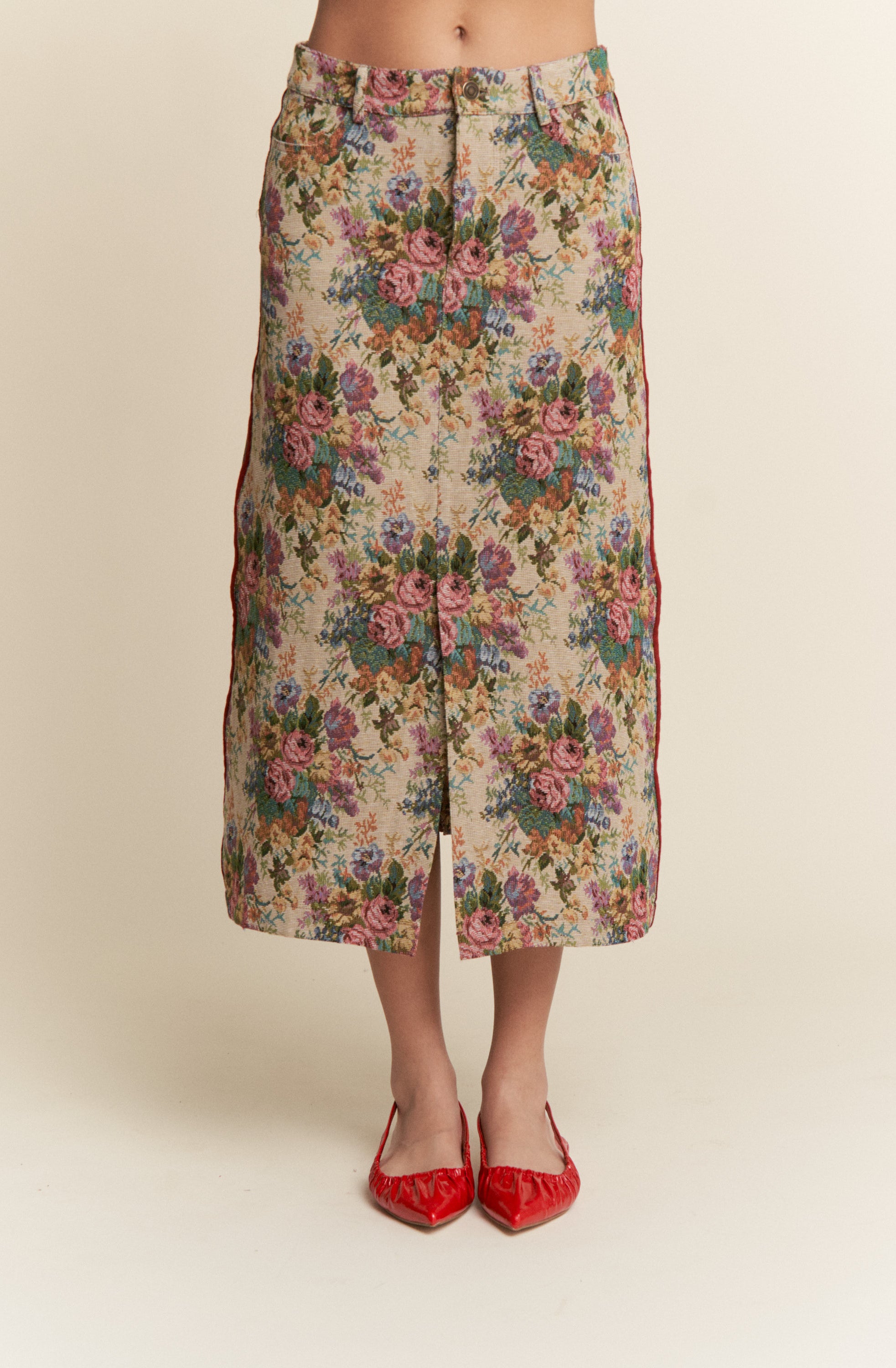 Floral patterned skirt worn by a person on a beige background