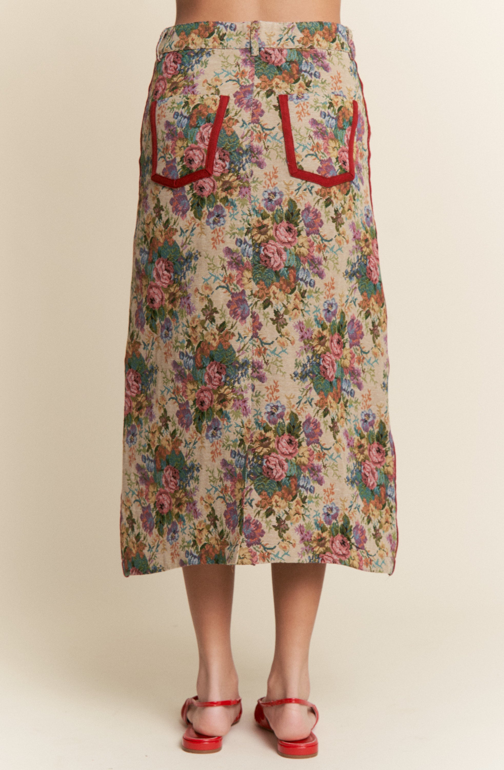 Floral skirt with red pocket details on a beige background