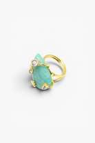 Gold ring with a green gemstone on a white background