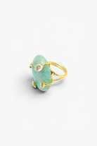 Gold ring with a green stone on a white background