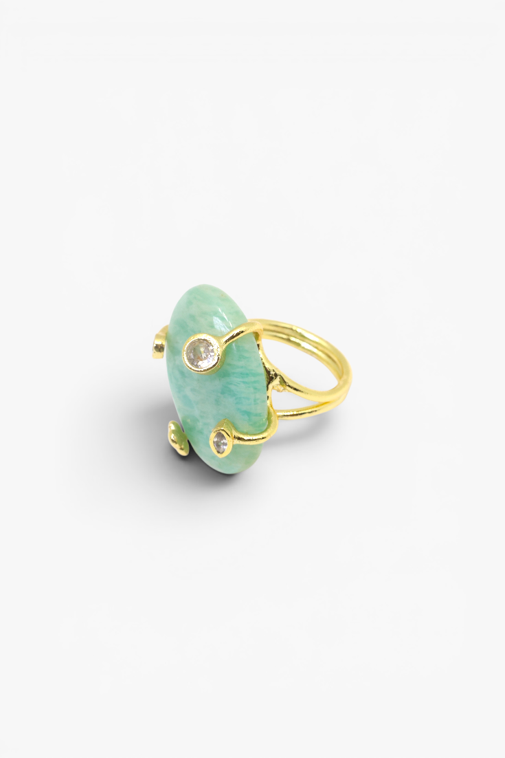 Gold ring with a green stone on a white background